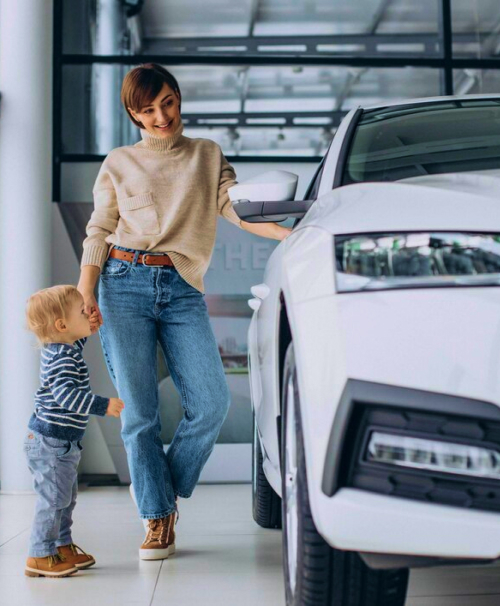 uma mulher com uma criança ao lado de um carro